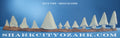 Decorative set of white shark models on a wooden base with a blue background and text. Jaws Megaladon shark teeth